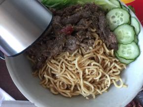 炒好将面条和牛肉装碗，撒上黑椒碎