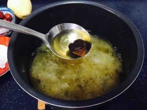 待放气后捞出大枣，用小勺挤压大枣，除去大枣皮和大枣核，枣肉留在锅里。