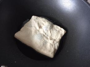 锅里倒入适量植物油热油锅后放入锅中小火焖煎