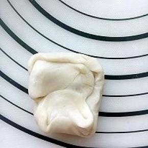 做好莲蓉玫瑰馅料，月饼面团也就醒发好了，取一个两边像中间合拢。