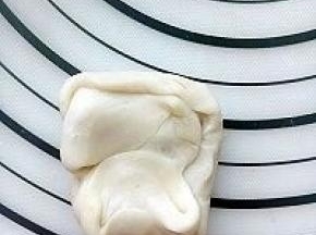 做好莲蓉玫瑰馅料，月饼面团也就醒发好了，取一个两边像中间合拢。