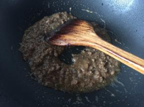 将水淀粉倒入炒散的肉末中