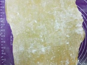 取出面团撒些玉米淀粉做手粉防粘，把面团擀薄，尽量厚薄均匀