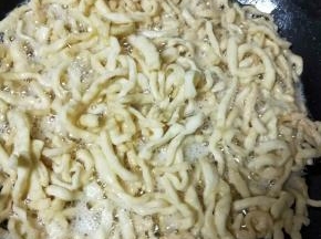 面条放入油中，炸至微微上色发黄就捞出来，不要炸过了