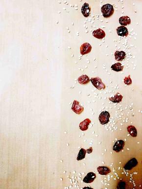 拿一个防粘模具，撒上些蔓越莓干和芝麻