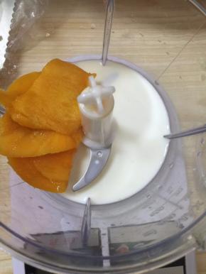 在料理机中加入芒果，牛奶，砂糖