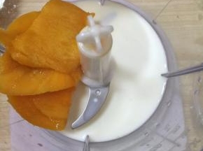 在料理机中加入芒果，牛奶，砂糖