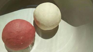 将白面团和红面团的食材分别混合，揉成光滑的面团，放在温暖处发酵