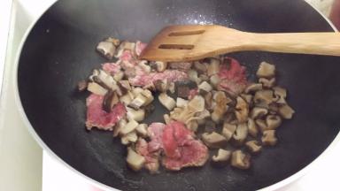热锅加入油，放入牛肉炒一下，再加入花菇。炒一下。