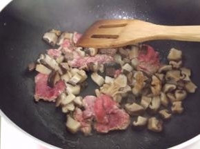 热锅加入油，放入牛肉炒一下，再加入花菇。炒一下。
