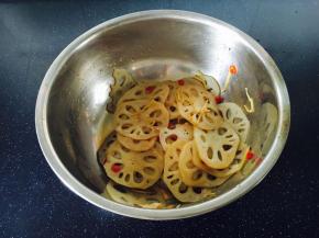 把煮过的汁水倒入拌菜的容器里，用我们平时盛米饭的木铲子从底部轻轻翻动，并时尔晃动容器，让藕片均匀的挂上汁水。