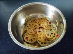 把煮过的汁水倒入拌菜的容器里，用我们平时盛米饭的木铲子从底部轻轻翻动，并时尔晃动容器，让藕片均匀的挂上汁水。
