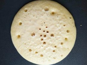 大约两分钟，玉米饼底部凝固成金黄色晃动锅玉米饼能在锅底滑动，饼的表面布满气泡，即可翻面(做玉米饼锅内不要抹油)