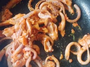 放入腌好的鱿鱼，大火爆炒。