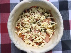 再洒上一层马苏里拉芝士碎，做到这了为一层披萨层，接着放另一片圆饼底……