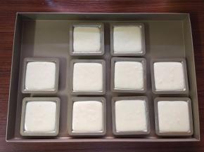 取出冷藏过的费南雪模具，将制作好的费南雪面糊装入裱花袋挤入模具中（八九分满）