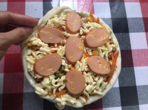 直至3层饼底和馅料全部放好，将之前预留的披萨边滚上包住边缘