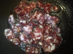 锅中加入少许油，大火烧热，下入腊肠中火翻炒。