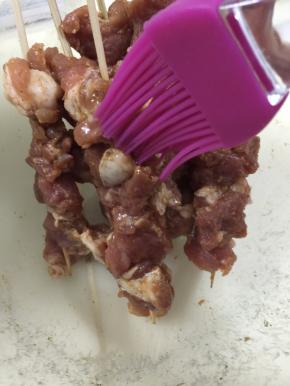 7. 在穿好的肉串上刷上花生油