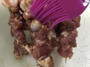 7. 在穿好的肉串上刷上花生油