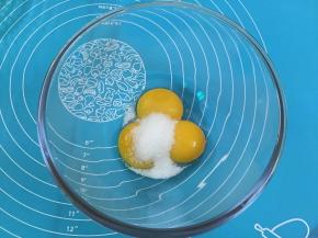 4. 在蛋黄糊中加人细砂糖，用手动打蛋器搅拌