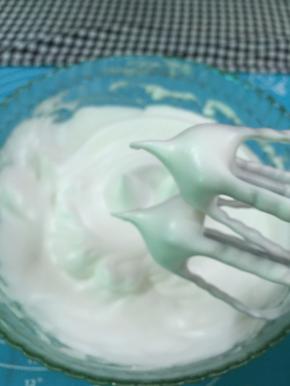 11. 高速打发至蛋白变得泡沫细腻，打至蛋白霜拉起的尖角轻轻下弯就说明打发好了，（如图）