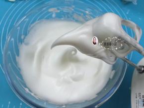 9. 中速打发至蛋白变得泡沫细腻，打至蛋白霜拉起的大弯钩下弯就说明发好了，（如图）