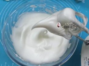 9. 中速打发至蛋白变得泡沫细腻，打至蛋白霜拉起的大弯钩下弯就说明发好了，（如图）