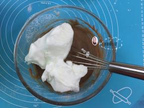 13. 将1/2的蛋白霜倒入蛋黄糊中，用手动打蛋器从盆底由下向上快速翻拌（不习惯用手动打蛋器的朋友请用硅胶刀