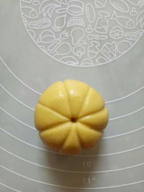 用虎口的位置向上抹，然后包圆，反过来稍稍压扁，用牙签在圆球上压出对称的米子形，中间戳上一个洞