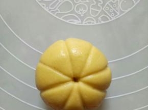 用虎口的位置向上抹，然后包圆，反过来稍稍压扁，用牙签在圆球上压出对称的米子形，中间戳上一个洞