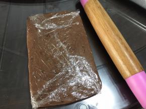 将保鲜膜对折包住面团，用擀面杖擀成长方形