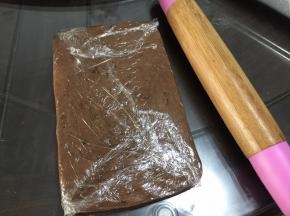 将保鲜膜对折包住面团，用擀面杖擀成长方形
