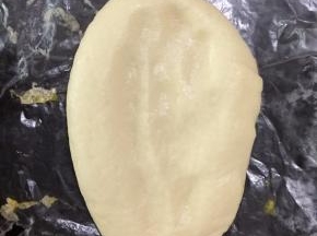 发酵好的面饼放在铺有油纸的烤盘上，用手指轻轻按压面饼中间