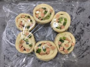 将面团切口朝上，在烤盘里铺上油纸，将面团摆出花型，盖上保鲜膜，发酵至1.5倍大