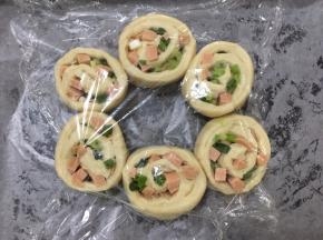 将面团切口朝上，在烤盘里铺上油纸，将面团摆出花型，盖上保鲜膜，发酵至1.5倍大