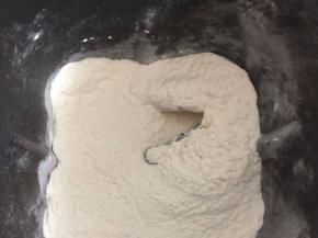 将低筋面粉和高筋面粉过筛后倒入面包机里，加入40g切小块黄油按和面键