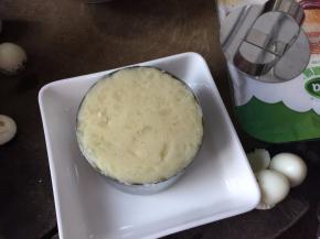 然后将压成泥状的土豆勺入圆形慕斯模具中压实