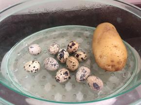 将土豆洗净和鹧鸪蛋放入蒸炉蒸熟