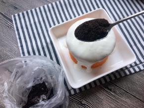 将碾碎的饼干碎勺入酸奶上