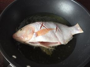 锅里热油后将鱼放入锅中炸