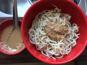 将凉开水滤去后勺入拌好的花生酱醋