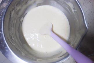 用刮刀隔着淋入温热的牛奶并用蛋抽拌大概30下，最后用刮刀把盆边的蛋糊拌匀