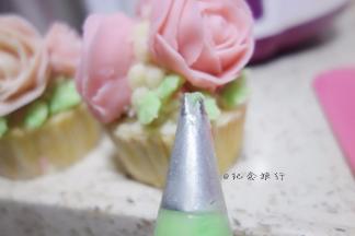 纸杯蛋糕抹上豆沙再挤一圈豆沙准备摆放裱好的玫瑰花摆放好后挤上叶子跟花苞