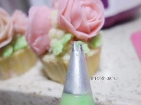 纸杯蛋糕抹上豆沙再挤一圈豆沙准备摆放裱好的玫瑰花摆放好后挤上叶子跟花苞