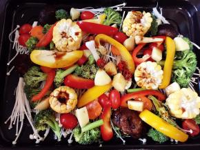 然后将所有蔬菜放入烤盘里，均匀淋入腌制鸡的酱汁