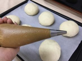 裱花袋内放入圆口裱花嘴，将酥皮糊放入裱花袋内