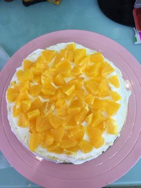 取一片蛋糕片，抹上奶油，均匀的铺上鲜橙丁。