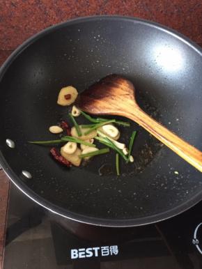 将炸好的鸡肉捞起沥干油份备用，倒出锅里多余的油，利用余油煸香姜片、蒜片、干红辣椒粒、葱段