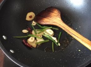 将炸好的鸡肉捞起沥干油份备用，倒出锅里多余的油，利用余油煸香姜片、蒜片、干红辣椒粒、葱段